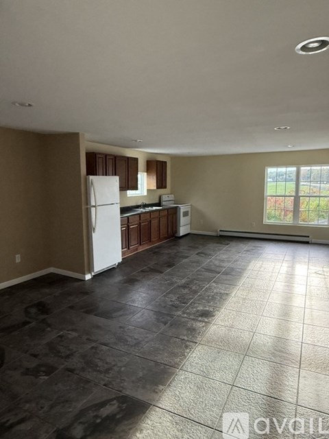 A kitchen with brown cabinets and a white refrigerator.