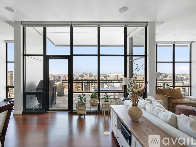 A modern living room with a view of the cityscape outside the large windows.