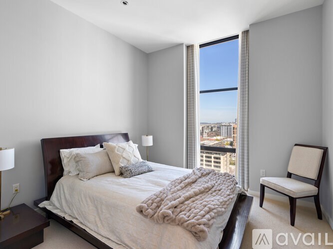 A bedroom with a large bed and a view of the city.