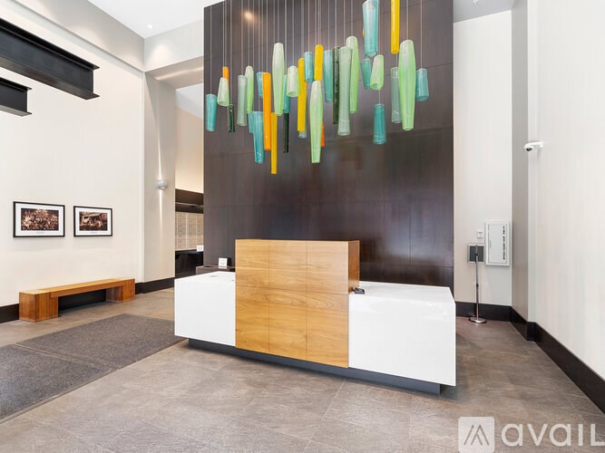 A reception area with a white reception desk and a colorful chandelier.