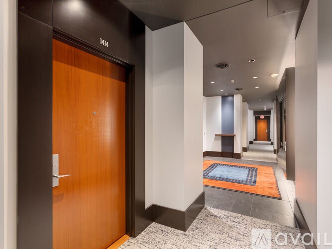 A hallway with a brown door and a carpet on the floor.