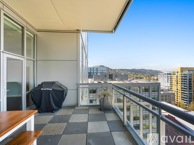 A balcony with a table and chairs overlooking a cityscape.