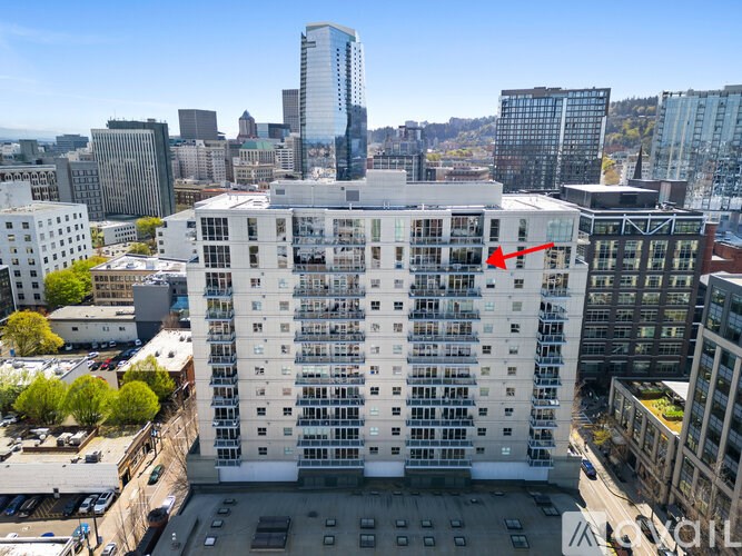 A tall white building with a red arrow pointing to the 10th floor from the bottom.