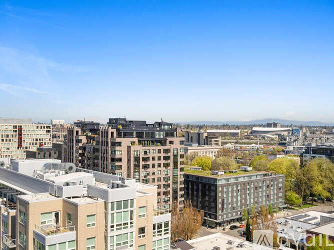 A cityscape with buildings of various heights and designs under a clear blue sky.