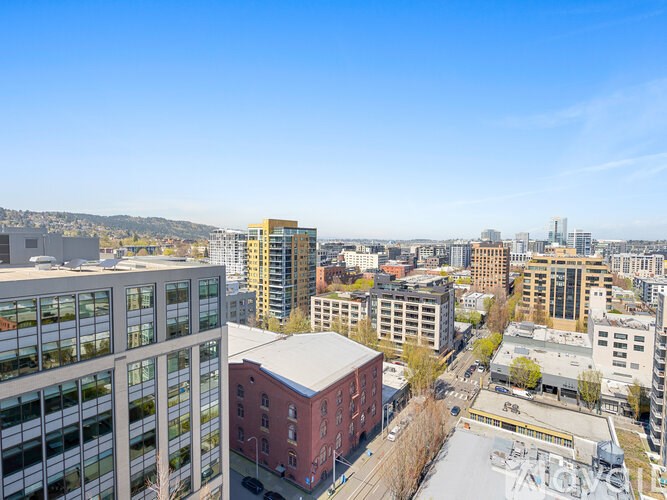 A cityscape with buildings of various heights and a clear blue sky.