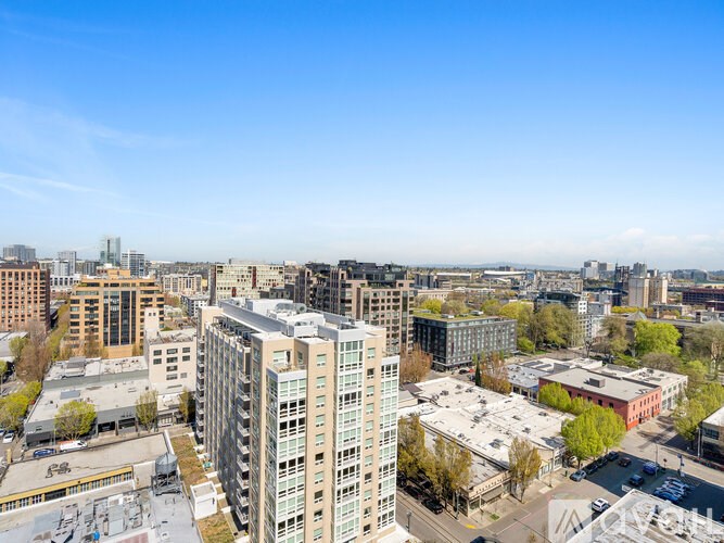 A cityscape with buildings and trees under a clear sky.