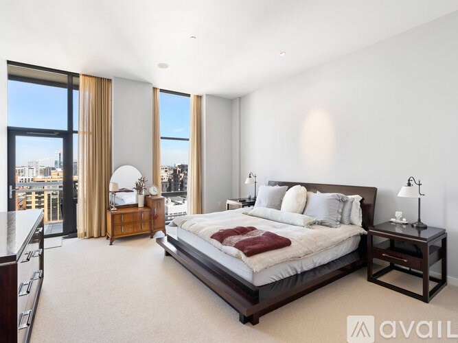 A bedroom with a large bed and a view of the city.
