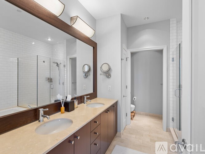 A bathroom with a double sink vanity and a large mirror.
