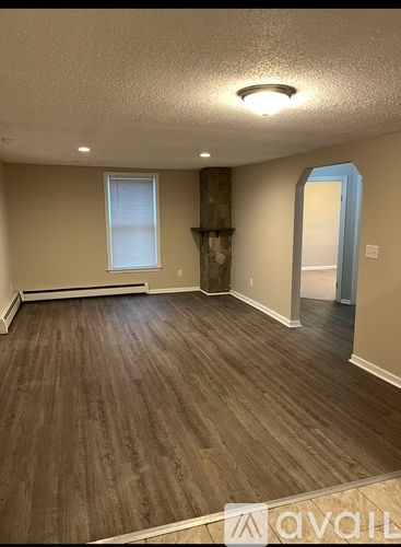 A room with wooden flooring and a window.