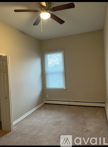 A room with a ceiling fan and a window.