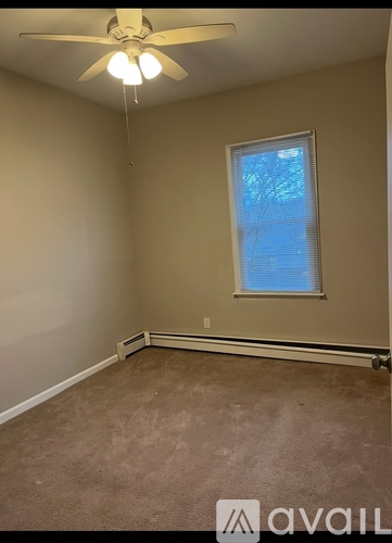 A room with a ceiling fan and a window.