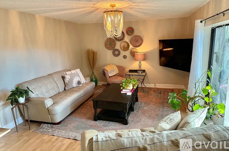 A living room with a couch, coffee table, and a flat screen TV.