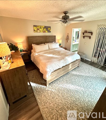 A bedroom with a large bed and a ceiling fan.