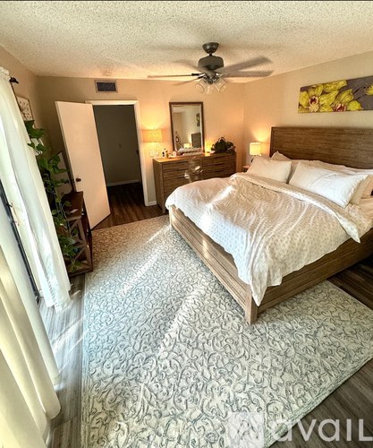 A bedroom with a large bed and a dresser with a mirror.