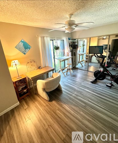 A living room with a white chair and a wooden floor.