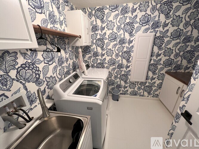A kitchen with a wallpapered wall and a white oven.