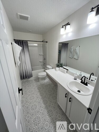 A bathroom with a patterned floor and a white sink.