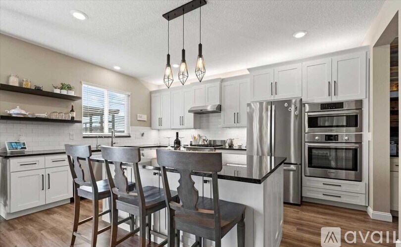 A modern kitchen with a center island and stainless steel appliances.
