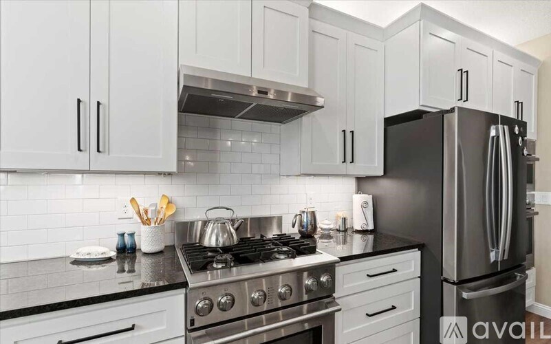 A modern kitchen with a stove top oven and a refrigerator.