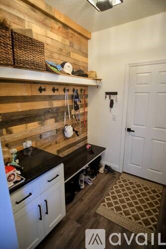 A kitchen with a wooden wall and white cabinets.