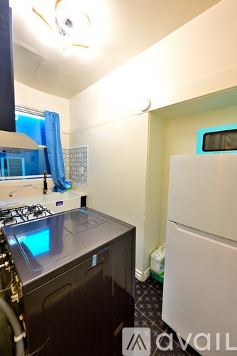 A small kitchen with a black stove top and a white fridge.