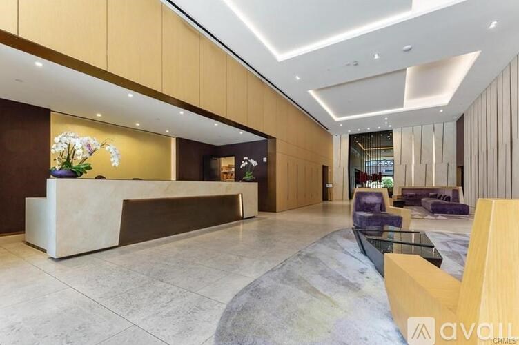 A reception area with a white reception desk and a purple sofa.