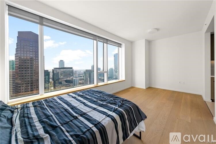 A bedroom with a large bed and a view of the city.