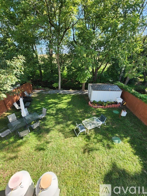 A backyard with a white grill and a picnic table.