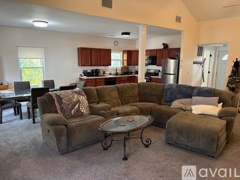 A living room with a grey couch and a glass coffee table.