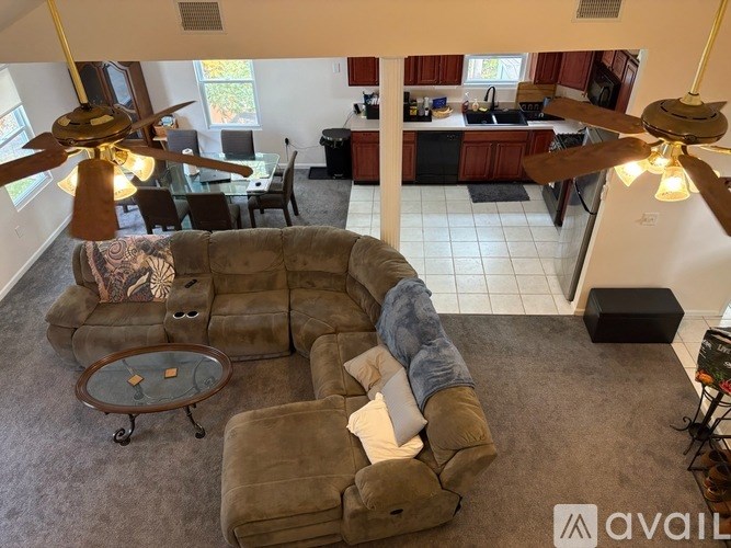 A living room with a couch and a fan.