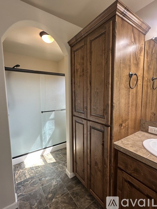 A bathroom with a wooden cabinet and a marble floor.