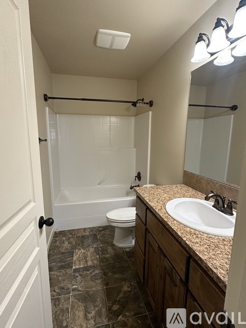 A bathroom with a toilet, sink, and shower.