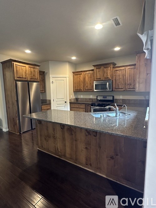 A kitchen with wooden cabinets and a granite countertop.