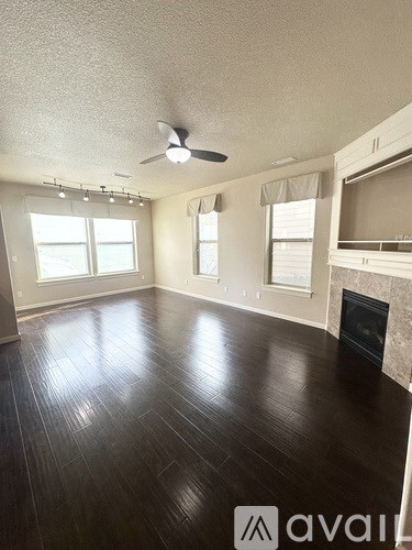 A living room with a fireplace and wood flooring.
