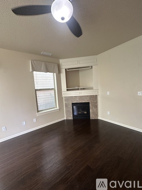 A room with a fireplace and a fan on the ceiling.