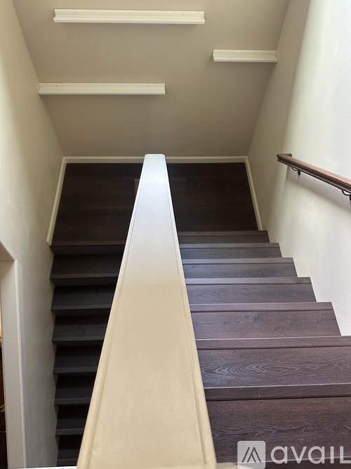 A staircase with a white railing and wooden steps.