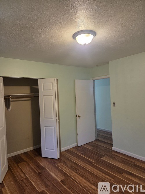 A room with a wooden floor and a white door.