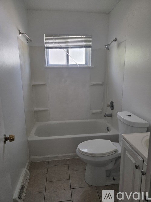 A white bathroom with a toilet, tub, and sink.
