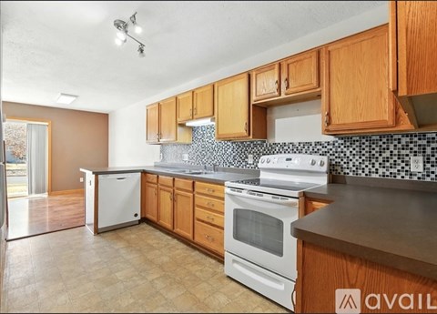 A kitchen with wooden cabinets and a white stove top oven.
