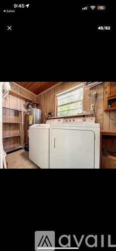A white refrigerator in a room with wooden walls.
