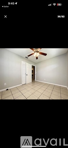 A room with a ceiling fan and tiled floor.