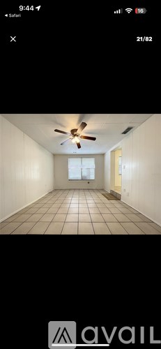 A room with a ceiling fan and tiled floor.