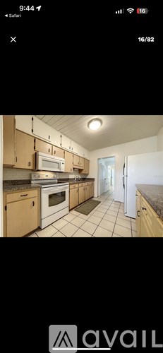 A kitchen with wooden cabinets and a white refrigerator.