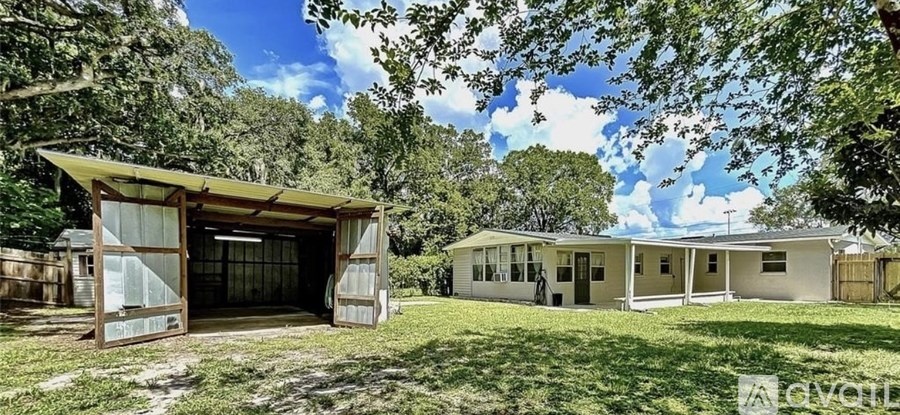 A house with a garage is surrounded by trees.