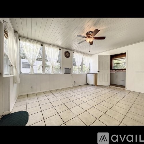 A room with a ceiling fan and tiled flooring.