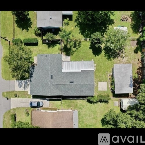 A car is parked in front of a grey building.