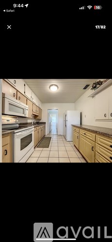 A kitchen with wooden cabinets and a tiled floor.