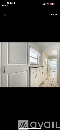 A white kitchen with a tiled floor and white cabinets.