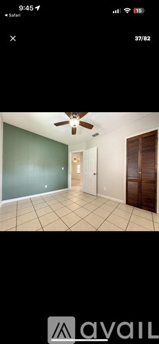 A room with a ceiling fan and tiled floor.