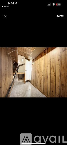 A long hallway with wooden walls and a door at the end.